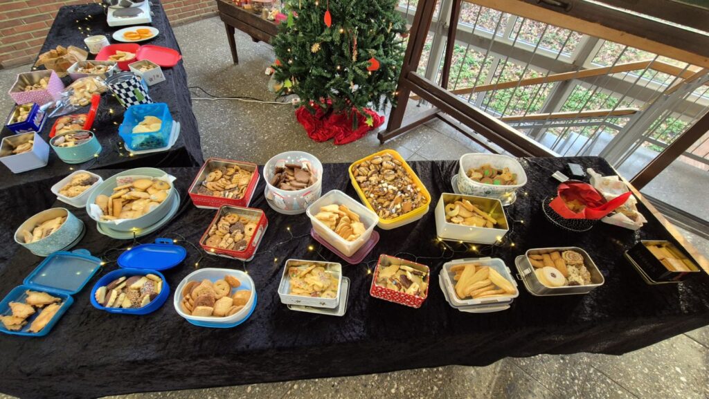 Buffet mit vielen mitgebrachten Speisen und Snacks bei einem gemeinsamen Schultreffen.
